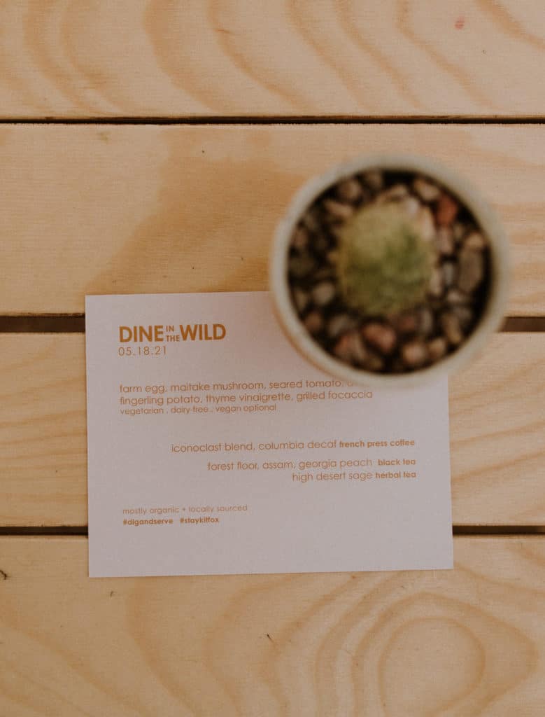 A Simple Menu Sits on a Rustic Wooden Table with Cactus Succulant Giving off a Desert Aesthetic