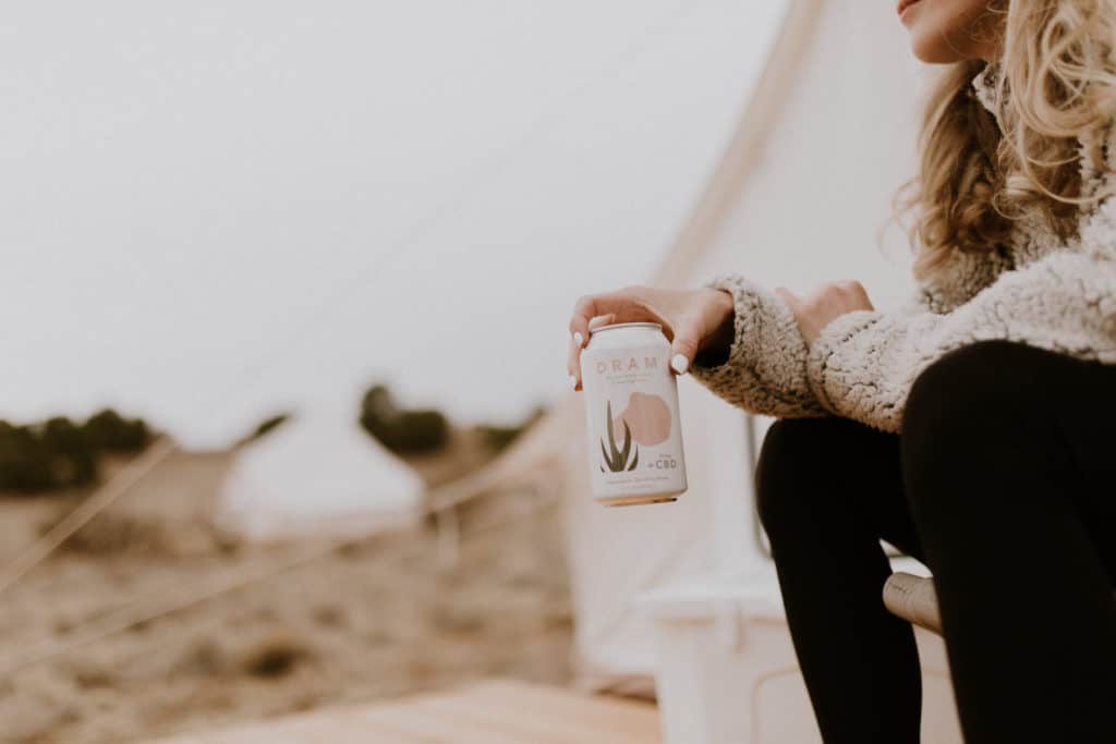 Girl Holding CBD Sparlking Water from Dram Apothecary