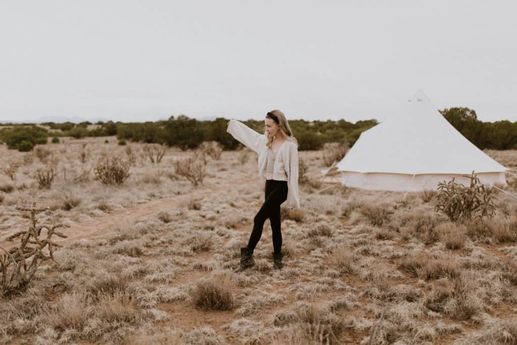 Girl Stands by White Canvas Style Safari Tent at Glamping Resort in Santa Fe New Mexico