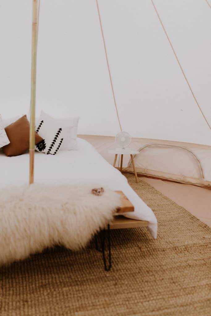 White Bed Inside of Glamping Tent in New Mexico with Sheepskin and a Southwest Style