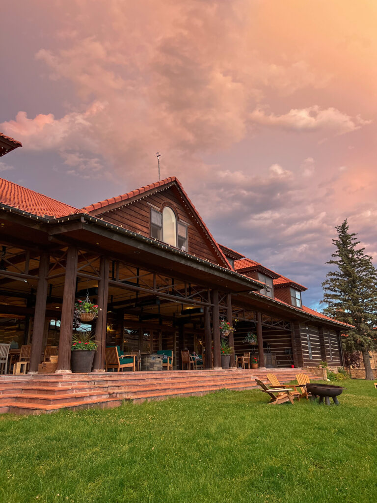 View of log cabin with sunset behind it